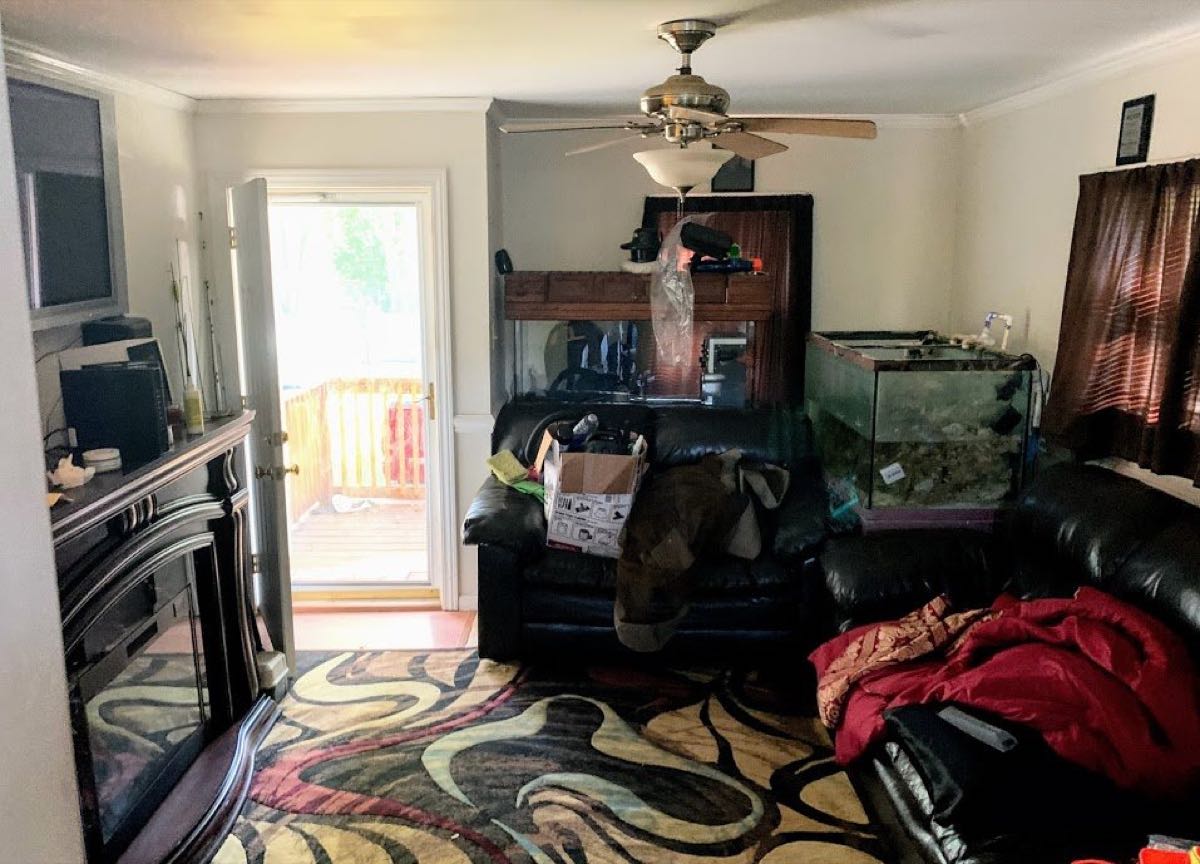 Living room full of belongings in a Mount Holly house purchased as-is